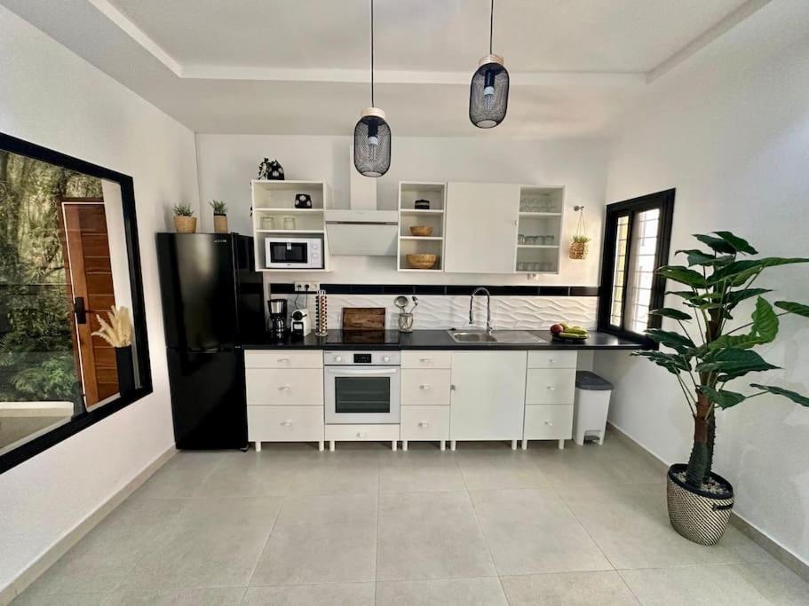 a kitchen with white appliances and a potted plant at Appartement 3 pièces Dakar in Dakar
