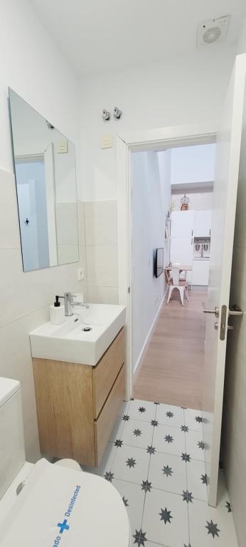 een badkamer met een wastafel, een toilet en een spiegel bij La buhardilla in Sevilla