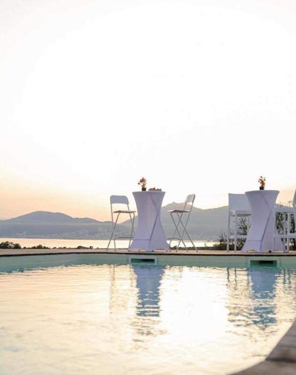 un groupe de chaises assises à côté d'une piscine dans l'établissement Villa Santoni 2, à Grosseto-Prugna