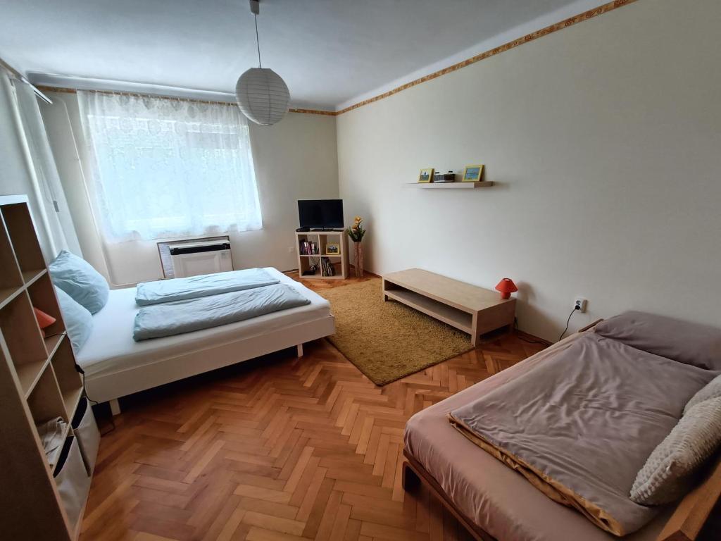 Habitación pequeña con 2 camas y ventana en NewIsland Family Apartman en Sárvár