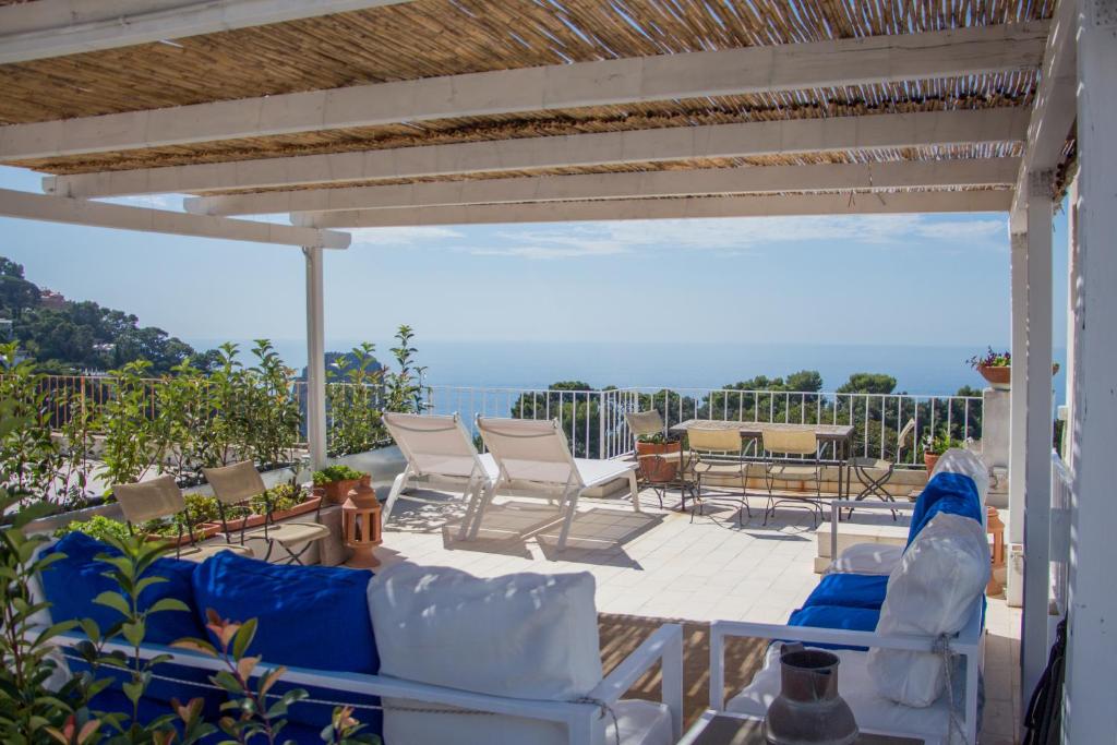 a patio with white furniture and a view of the ocean at Attico Capri in Capri