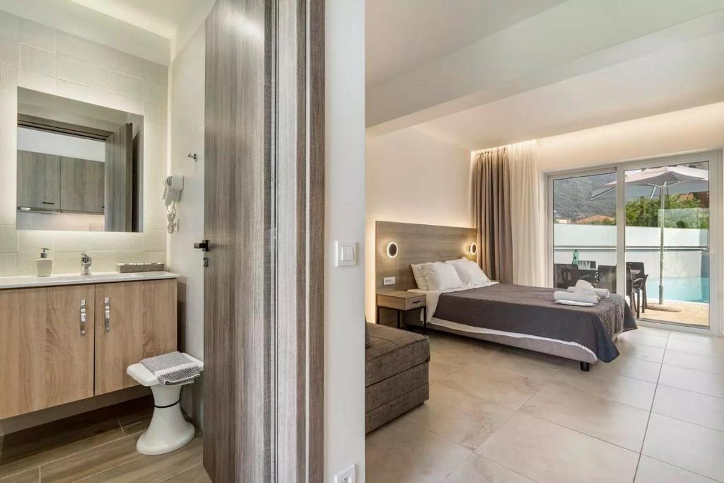 1 dormitorio con 1 cama y baño con lavamanos en Papatsas Center Houses en Nydri