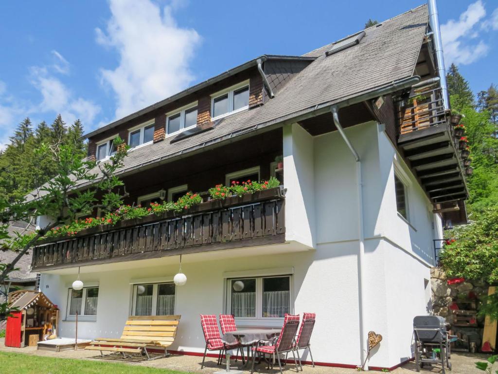a house with a balcony with a table and chairs at Apartment Haus Ganter by Interhome in Hinterzarten
