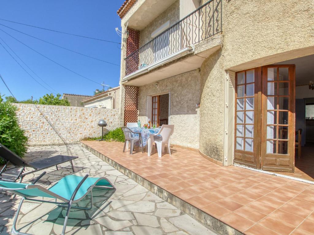 a patio with a table and chairs in front of a building at Apartment La Caterina-1 by Interhome in Saint-Cyr-sur-Mer