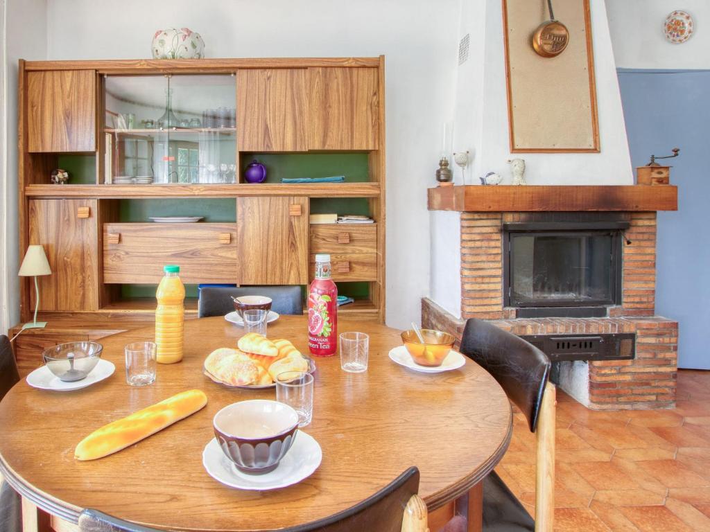 a wooden table with plates of food and a fireplace at Apartment La Caterina-1 by Interhome in Saint-Cyr-sur-Mer