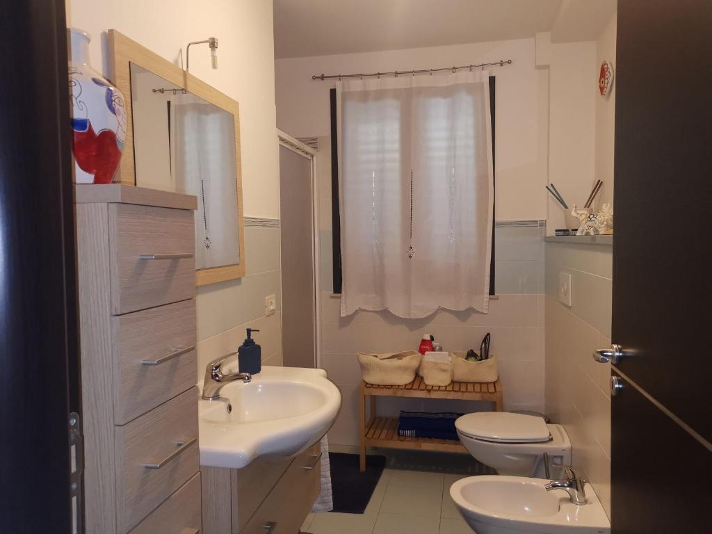 łazienka z 2 umywalkami, toaletą i oknem w obiekcie Pretty Home w mieście Acireale