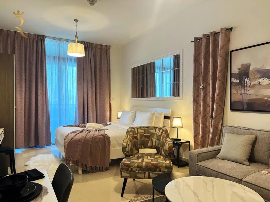 a hotel room with a bed and a chair and a couch at Studio Escape in Al Reem Oasis Euphoria in Abu Dhabi