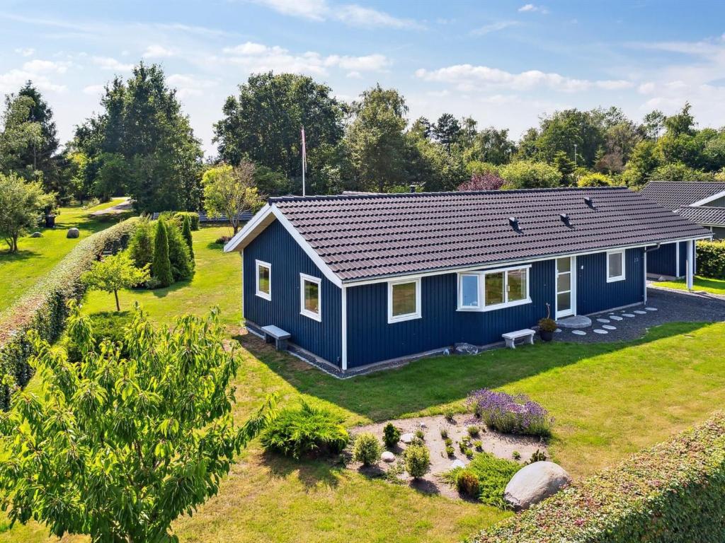una casa azul con un jardín frente a ella en Holiday Home Asvalde - all inclusive - 200m to the inlet by Interhome, en Vordingborg