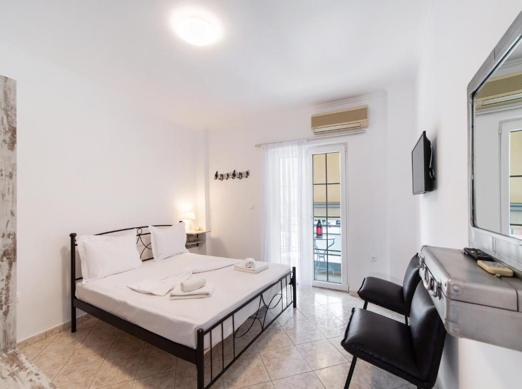 a bedroom with a bed and a chair in a room at Filippa City Apartments - Lefkada Town Center in Lefkada