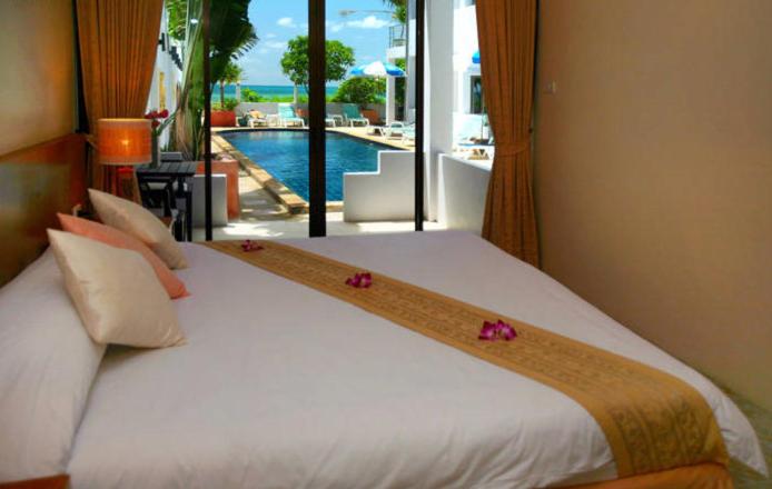 Un dormitorio con una gran cama blanca con flores. en Kamala Dreams, en Kamala Beach