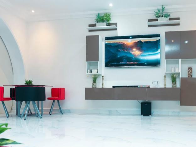 Habitación con TV en una pared con sillas rojas en Luxury home with class, en Accra