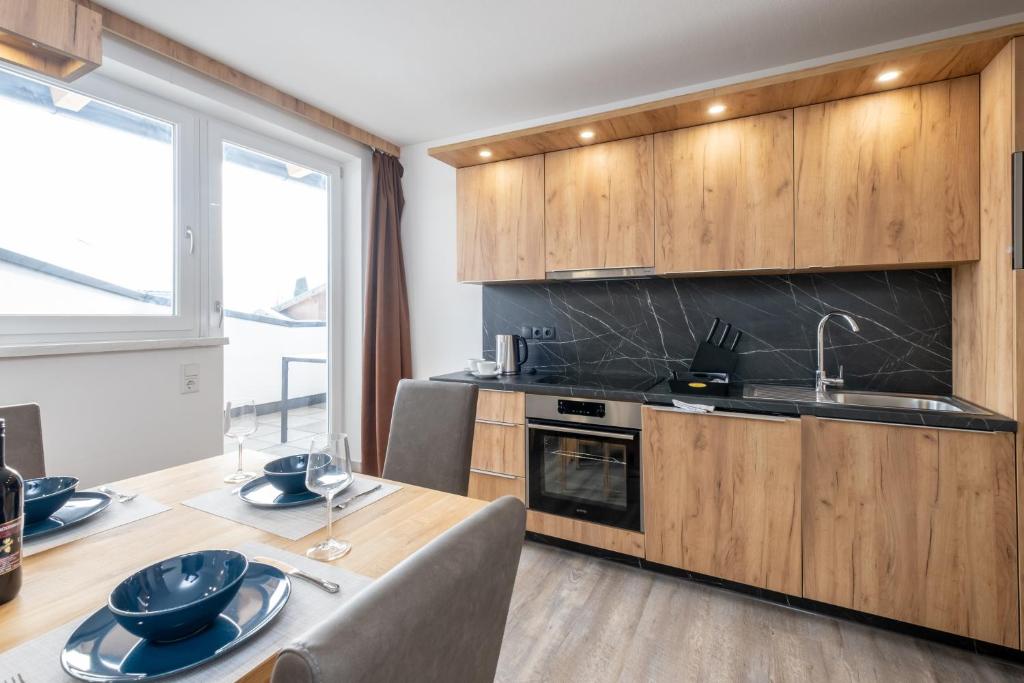 een keuken met houten kasten en een tafel met een wastafel bij TOP 8 Apartment - Zell am See - Kaprun in Piesendorf