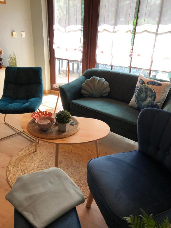 uma sala de estar com sofás azuis e uma mesa em Ferienhaus "Buddelschiff" em Ueckermünde