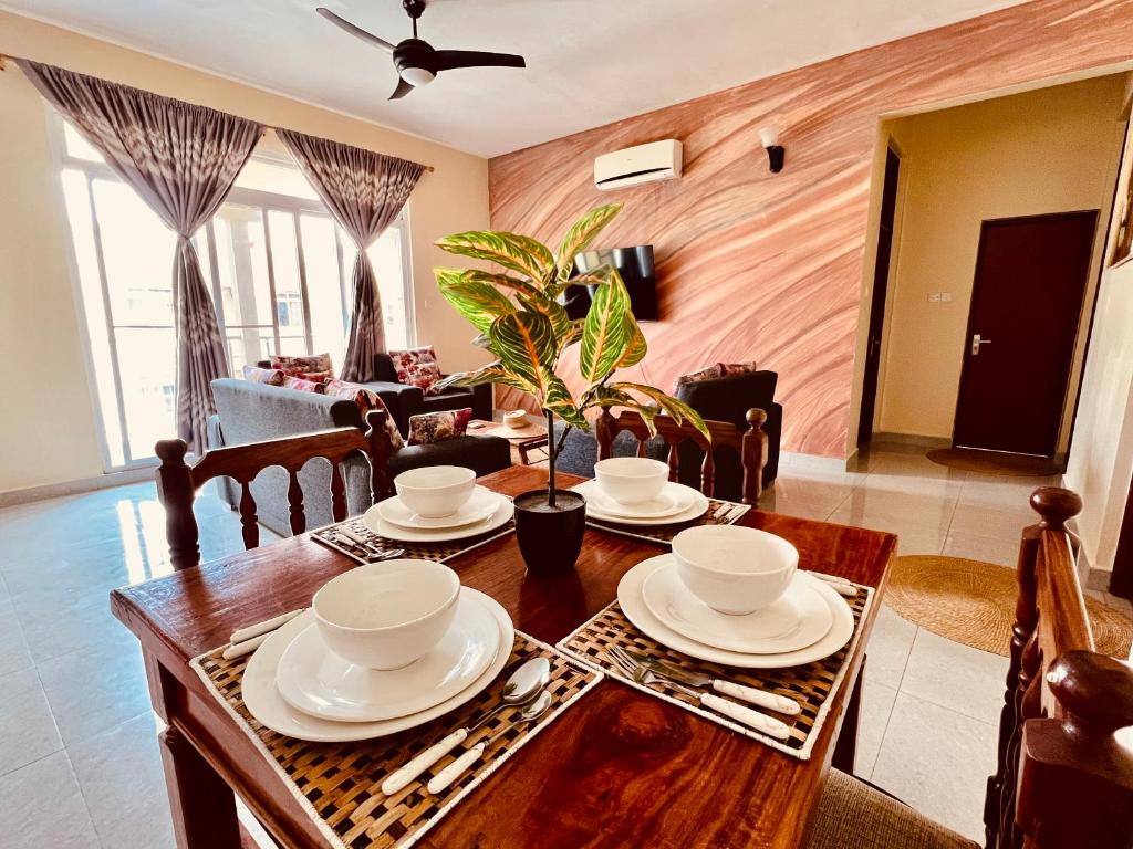 comedor con mesa de madera y sillas en Africa Mbweni Apartment en Kiembi Samaki