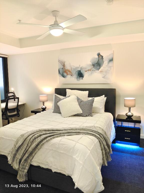a bedroom with a bed with a ceiling fan at Adelaide City Loft in Adelaide