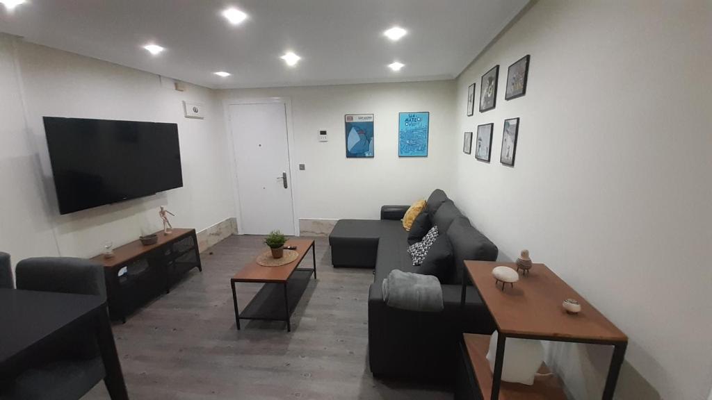 sala de estar con sofá y TV de pantalla plana en Zuvillaga 14 en Oviedo