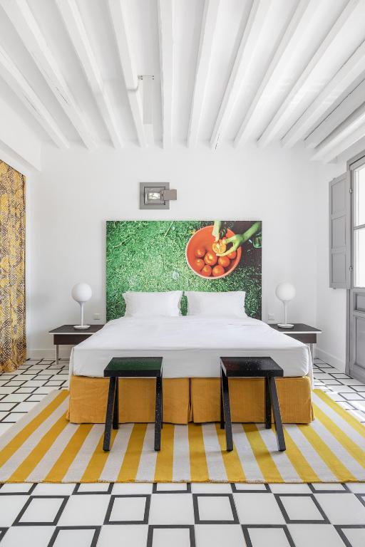 a bedroom with a bed and a painting on the wall at ANEMI Folegandros in Karavostasi