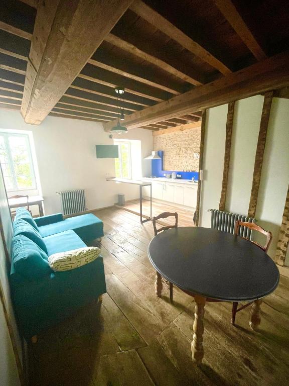 un salon avec une table et un canapé dans l'établissement Appartement au manoir de la grande vigne Mayenne, à Mayenne