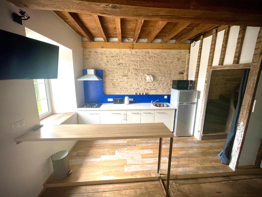 a kitchen with a sink and a refrigerator at Appartement au manoir de la grande vigne Mayenne in Mayenne