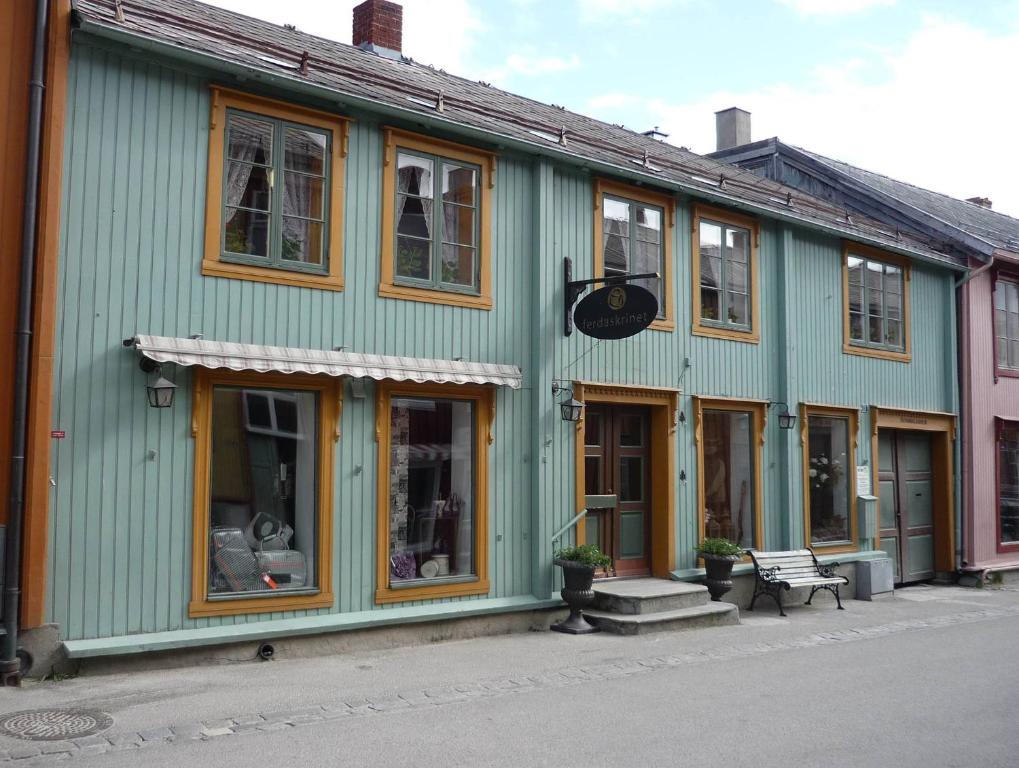 ein grünes Gebäude mit einer Bank davor in der Unterkunft Houmbgaarden in Røros