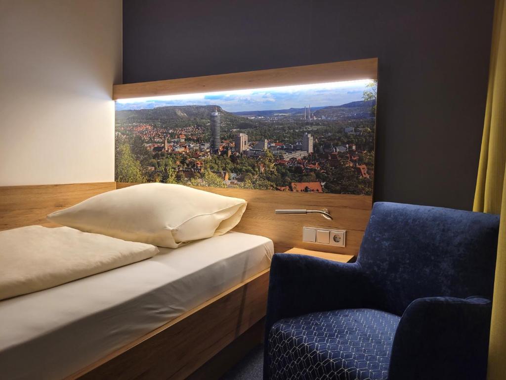 um quarto com uma janela com uma cama e uma cadeira em Akademiehotel Jena em Jena