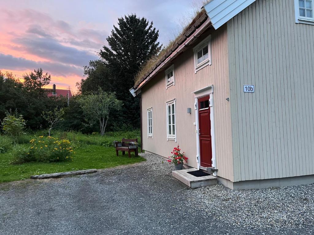 a pink building with a red door and a bench at Calm surroundings with hiking trails near Bodø and Saltstraumen in Bodø