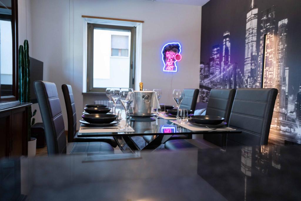 ein Esszimmer mit einem Tisch mit Stühlen und einem Neonschild in der Unterkunft New apartment Trento (parking) in Trient