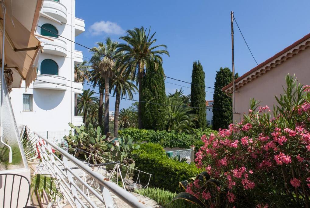 un escalier menant à un bâtiment avec des palmiers et des fleurs dans l'établissement Détente à Juan Les Pins 2 Pièces Climatisée à 500m des plages, à Antibes