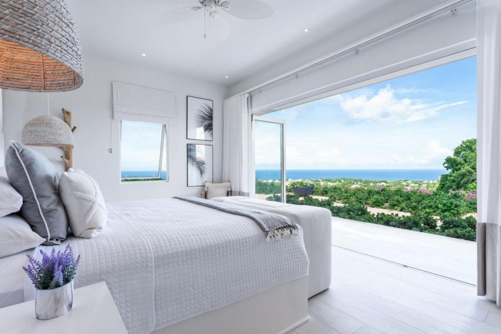um quarto branco com vista para o oceano em Incredible views of sea from the pool - Cool Breeze villa em Saint James