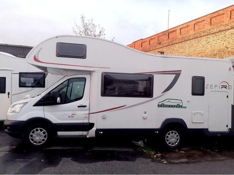 a white camper truck parked in a parking lot at easicampers in Wigan