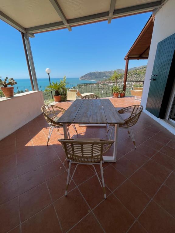 uma mesa e cadeiras num pátio com vista para o oceano em Villa Torre di Lupo- Manfredi Homes&Villas em Mattinata