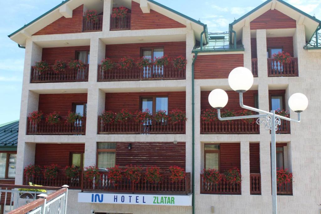 a hotel building with flower boxes on the balconies at IN Hotel Zlatar ex Zlatarski Biseri in Nova Varoš
