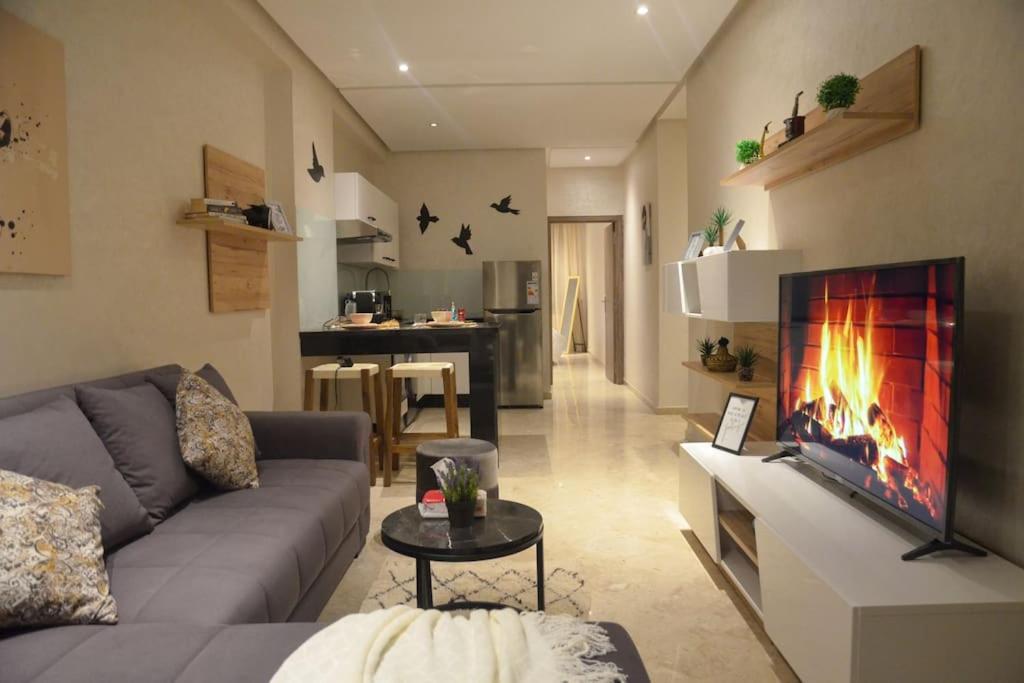 uma sala de estar com um sofá e uma lareira em Sumptuous Appartement Y&M em Marrakech