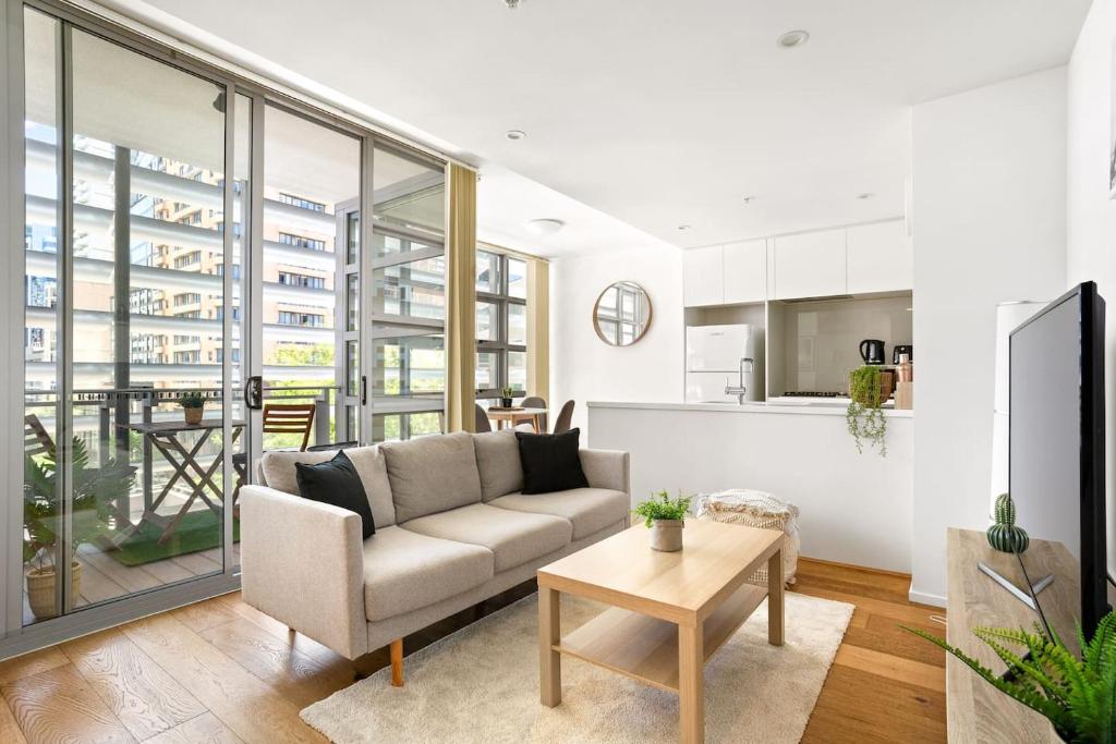 a living room with a couch and a kitchen at 'Sussex Suite' Sunny City Living by Darling Harbour in Sydney