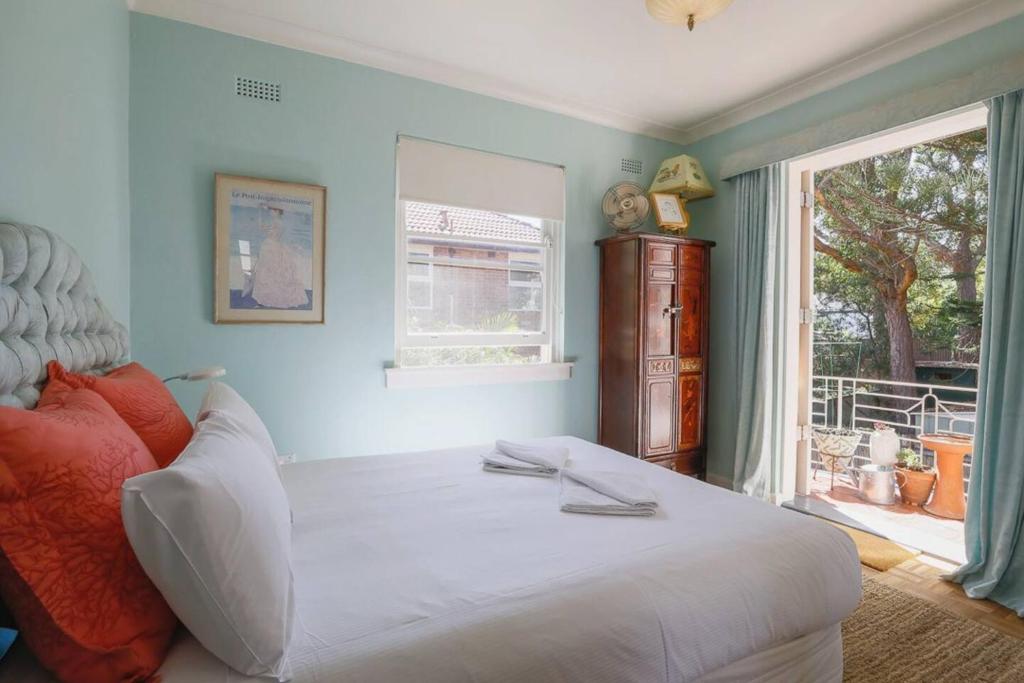- une chambre avec un grand lit blanc et une fenêtre dans l'établissement Art Deco at Marouba Beach - Soak up the Sand & Surf, à Sydney