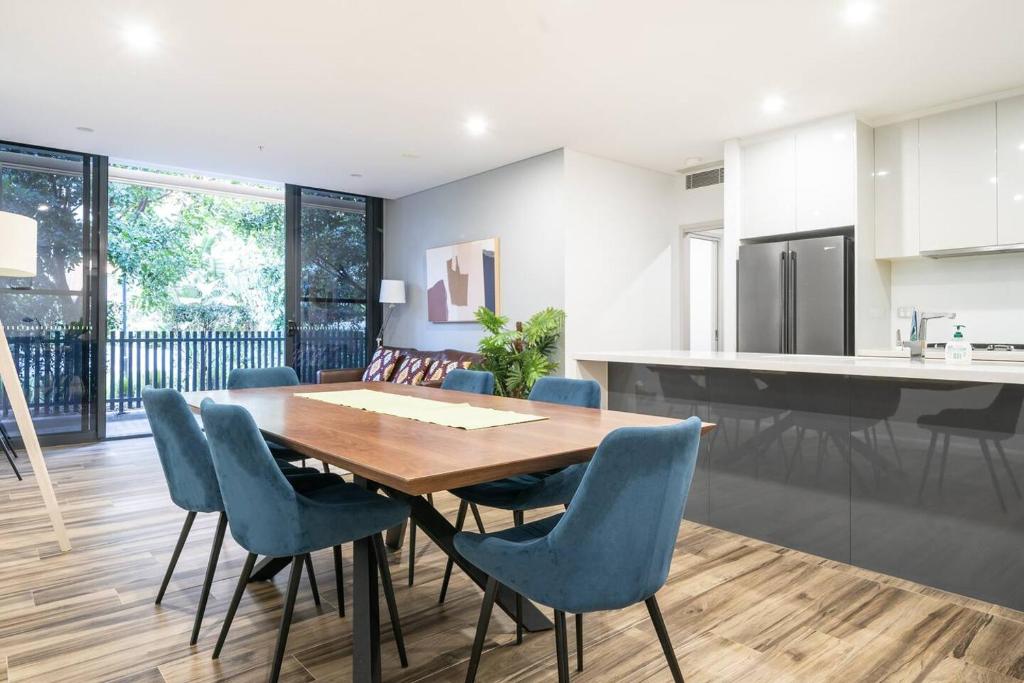 een keuken en eetkamer met een houten tafel en stoelen bij 'Eastgardens Splendour' Two-storey Style with Pool in Sydney