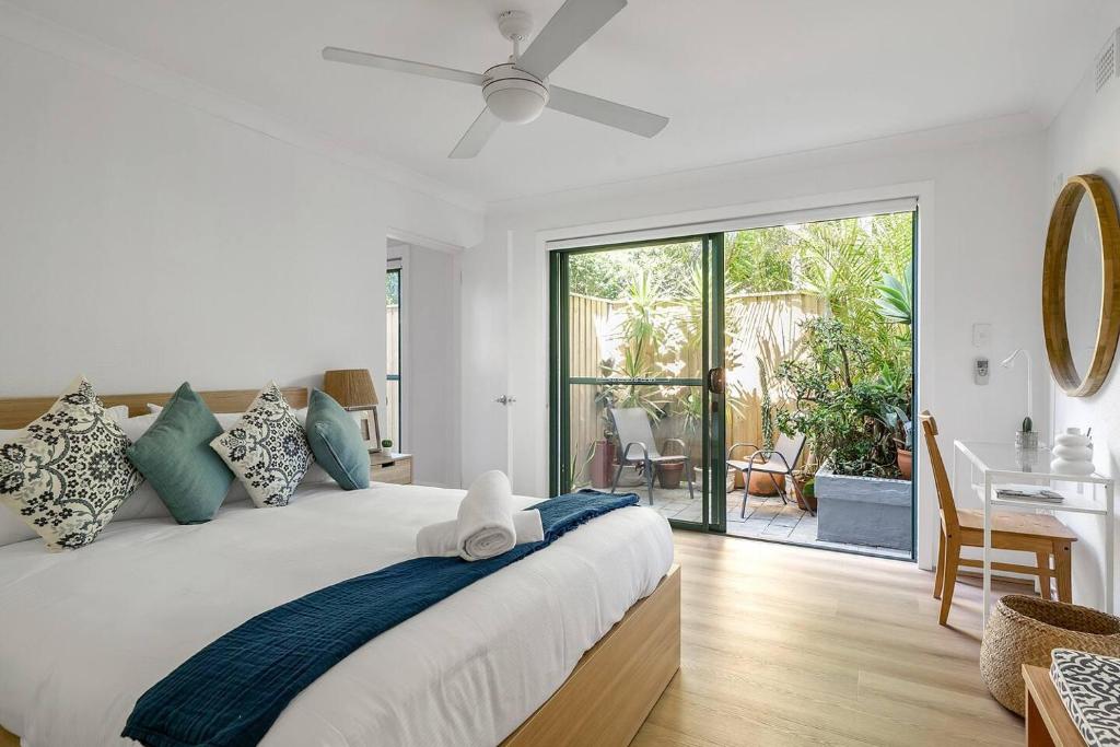 a bedroom with a bed with a ceiling fan and a desk at Bronte Haven - Coastal Bliss for Families in Sydney