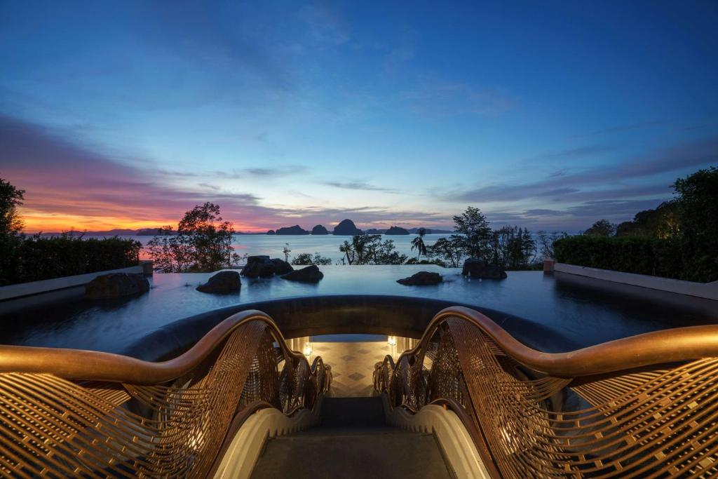a pool with a view of the ocean at sunset at Banyan Tree Krabi - SHA Extra Plus in Tab Kaek Beach