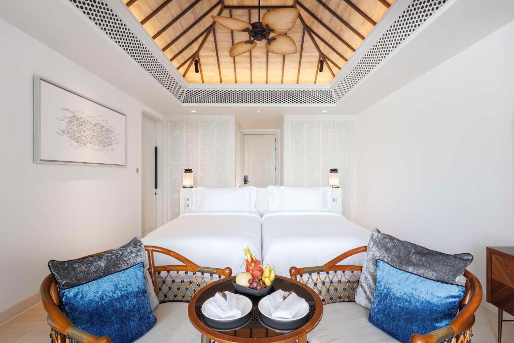 a bedroom with a large bed and two chairs at Banyan Tree Krabi in Tab Kaek Beach