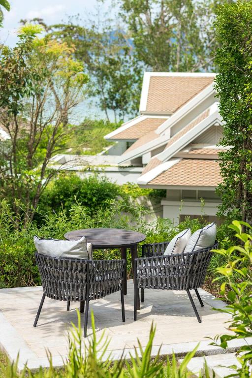 a patio with two chairs and a table in a yard at Banyan Tree Krabi in Tab Kaek Beach
