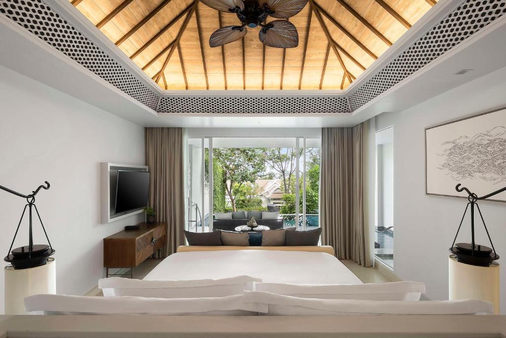 a bedroom with a large bed with a ceiling fan at Banyan Tree Krabi in Tab Kaek Beach