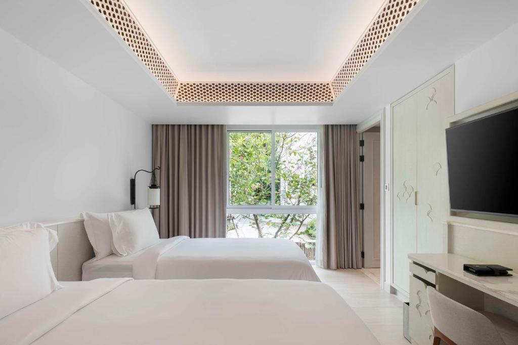 a hotel room with two beds and a flat screen tv at Banyan Tree Krabi in Tab Kaek Beach