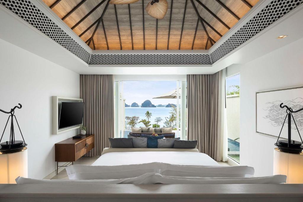 a bedroom with a bed and a large window at Banyan Tree Krabi in Tab Kaek Beach