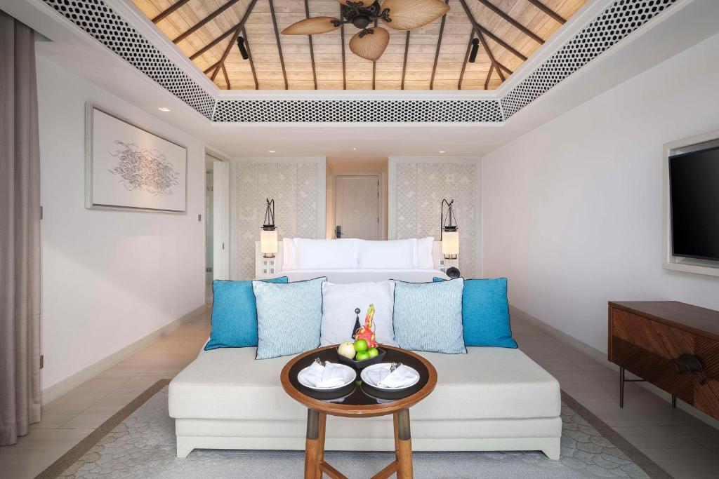 a living room with a couch and a tv at Banyan Tree Krabi in Tab Kaek Beach