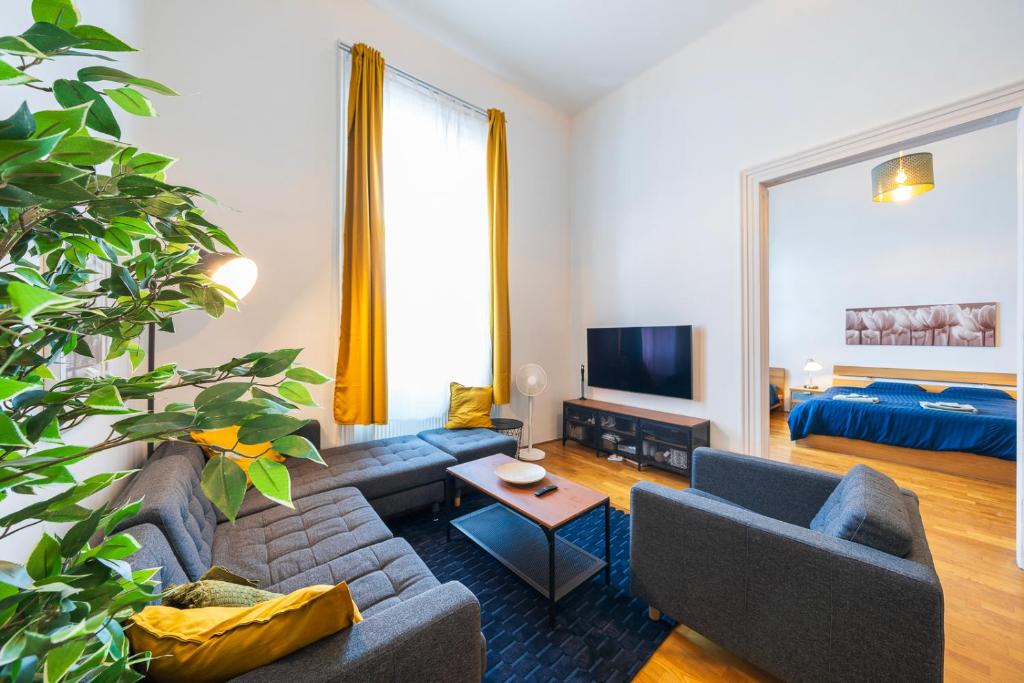 a living room with a couch and a tv at Shining bright two bedroom apt next to Andrassy ave in Budapest