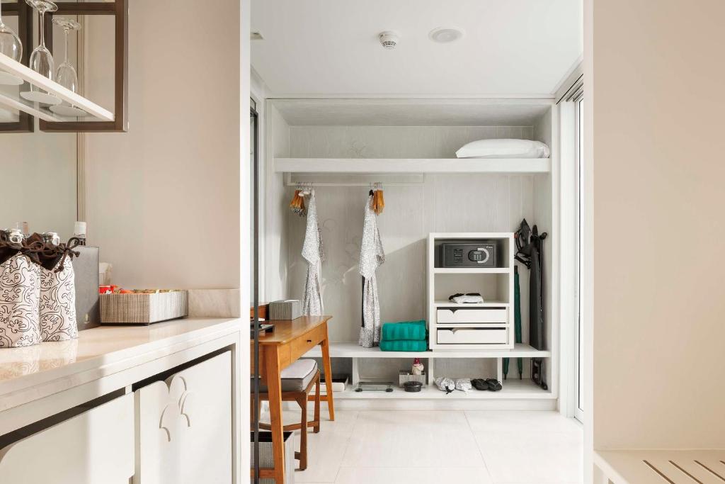 a kitchen with a desk and a microwave in a room at Banyan Tree Krabi in Tab Kaek Beach