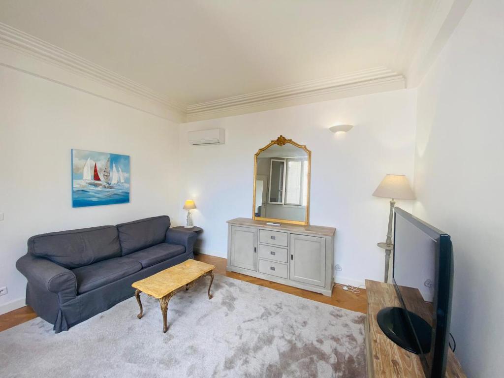 un salon avec un canapé et un miroir dans l'établissement Promenade des Anglais /Carré d'or - 2 mins plages, à Nice