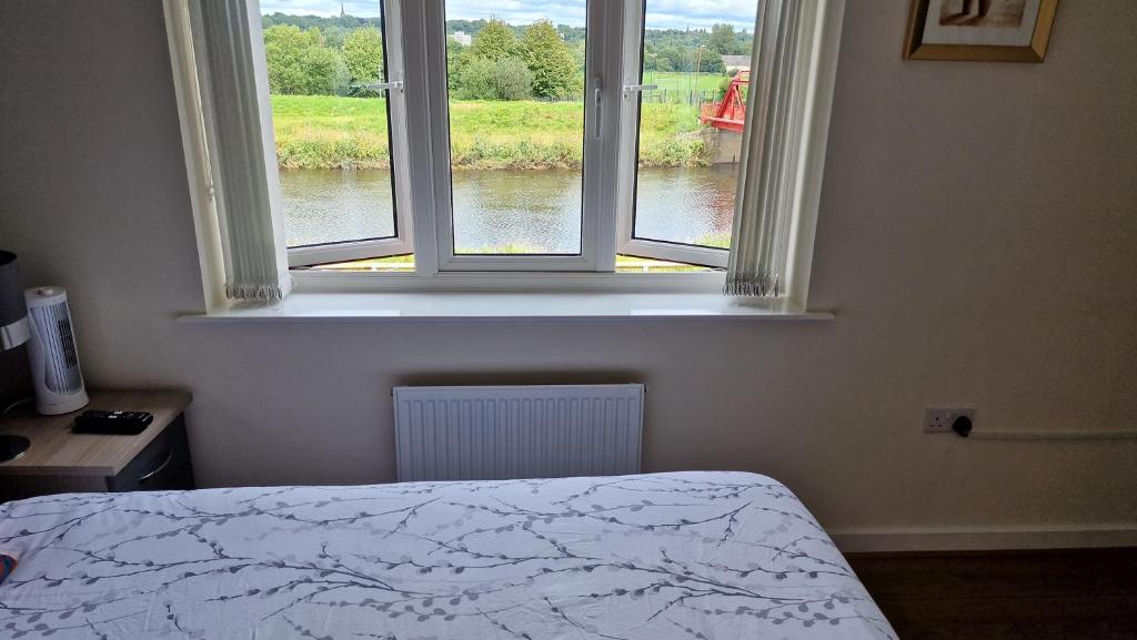 a bedroom with a bed and a window with a view of a river at Stunning 2-Bed House in Manchester with canal view in Manchester