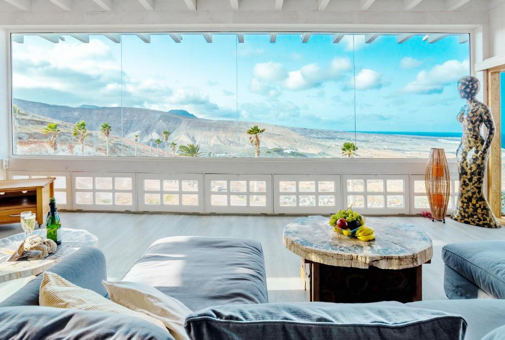 a living room with a view of the ocean at Eco Vineyard Cottage - Fantastic Views - 5 mins drive to Arrieta beach in Tabayesco