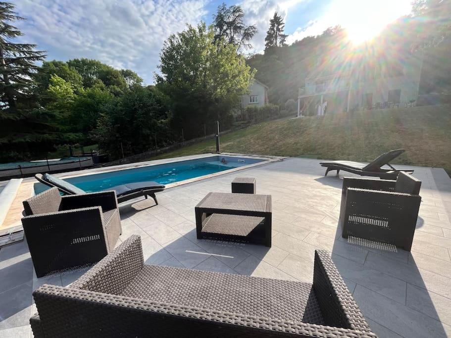 a patio with chairs and a pool with the sun at Maison de campagne proche Disney in Chamigny